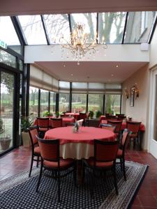 福尔登Wildenborcherhof的餐厅设有红色的桌椅和吊灯
