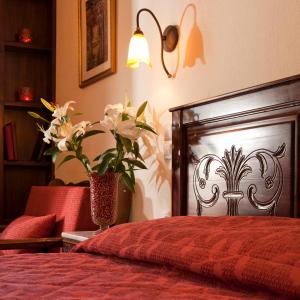 埃拉蒂特里卡隆弗莱特扎托公寓式酒店的一间卧室,配有一张红色的床和花瓶