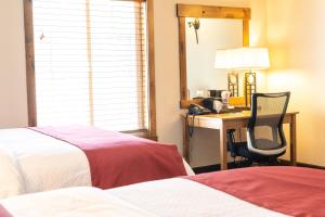 艾兰帕克萨特尔山度假酒店的酒店客房配有两张床和一张桌子及椅子