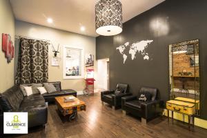多伦多The Clarence Park的客厅配有皮革家具,墙上挂有世界地图