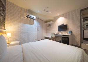 台北久居栈旅店的一间卧室配有一张床和一张书桌及电视