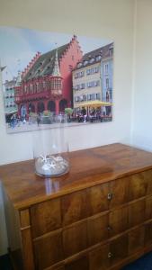 弗莱堡中央公寓酒店的木梳妆台上的一个玻璃瓶