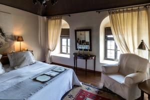卡瓦拉伊马雷特酒店的一间卧室配有一张床、一把椅子和窗户。