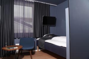 弗莱克菲尤尔马里提姆峡湾酒店的一间卧室配有一张床、一张桌子和一台电视。