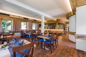 雷金根布林恩霍恩酒店的餐厅设有木桌和蓝色椅子