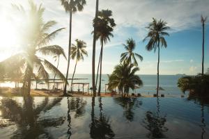 湄南海滩Napasai, A Belmond Hotel, Koh Samui的棕榈树和海洋海滩上的游泳池