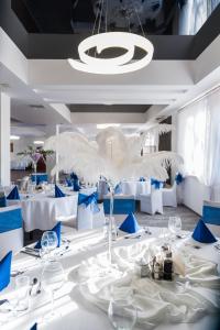 热舒夫霍尔里宗酒店的用餐室配有白色的桌子和蓝色的椅子
