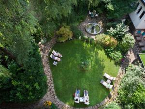 萨尔茨堡Boutique Hotel & Villa AUERSPERG的花园顶部景色,设有椅子和喷泉