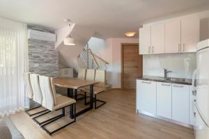 克拉尼斯卡戈拉Vila Vita Apartments的厨房以及带木桌和椅子的用餐室。