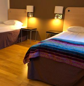 夏洛滕贝格Hotell Charlottenberg的酒店客房,设有床铺和2个床头柜