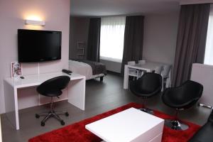 奥纲赖泽全景酒店的客厅设有1间带电视和椅子的房间