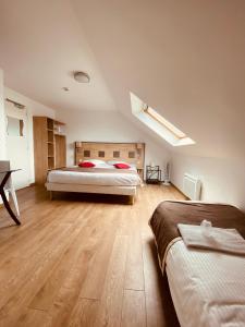 博库泽Atoll Hotel Logis Angers, Beaucouzé的一间卧室设有两张床,铺有木地板