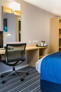 霍尔曼彻斯特机场智选假日酒店的客房设有一张床和一张带椅子的桌子
