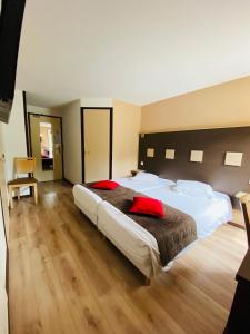 博库泽Atoll Hotel Logis Angers, Beaucouzé的酒店客房配有一张带红色枕头的大床