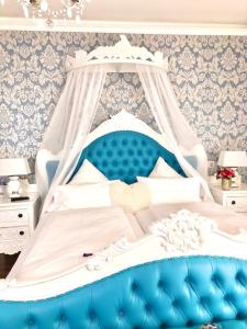 巴登韦勒Boutiquehotel Villa Rosenhof的一张蓝色和白色的天蓬床