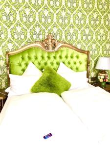 巴登韦勒Boutiquehotel Villa Rosenhof的一间卧室配有一张带绿色床头板的床
