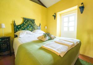 蒙塔吉尔葡萄牙蒙特酒店的一间卧室设有一张黄色墙壁和窗户的床