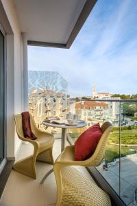 法蒂玛Serra d'Aire Boutique Hotel - SA Hotels的阳台配有桌椅和大窗户。