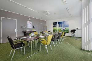 杜塞尔多夫Tulip Inn Hotel Düsseldorf Arena的一间带长桌和黄色椅子的用餐室