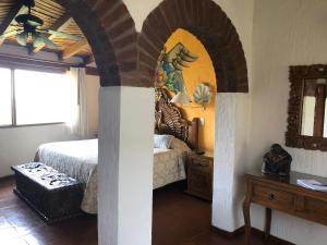 莫雷利亚圣何塞别墅套房酒店 的一间卧室配有一张床、一张桌子和一面镜子