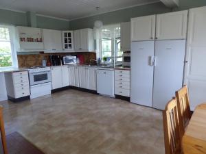 林雪平Villa Freja的厨房配有白色橱柜、电器和桌子