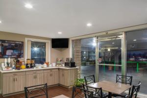 彭萨科拉Super 8 by Wyndham Pensacola NAS Area的厨房配有桌子和桌椅