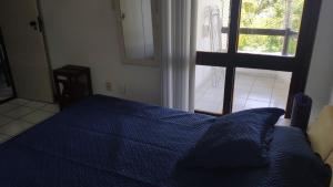 GamboaIlha dos Corais的一间卧室设有蓝色的床和窗户。