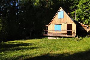OpátkaMalebná chata v lese的草场上带甲板的小屋