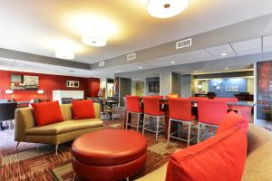 佩恩提德波斯特佩恩蒂德智选假日酒店的酒店大堂设有红色椅子和酒吧