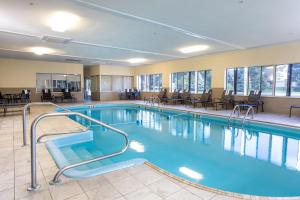 桑达斯基Quality Inn & Suites Sandusky的一座配有桌椅的酒店游泳池