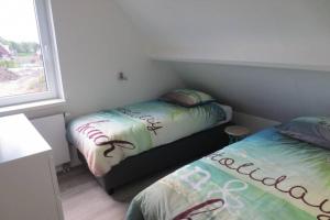 佐特兰德Luxe vakantiewoning dicht bij strand的一间小卧室,配有两张床和窗户