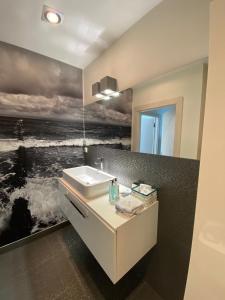 米兹多洛杰Apartament 37 Playa Baltis przy plaży的一间带水槽和海洋绘画的浴室