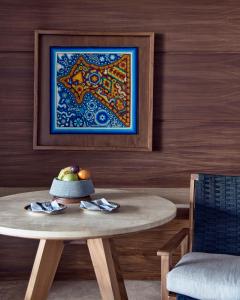 蓬塔米塔蓬美达四季度假酒店的一张桌子,上面放着一碗水果和一幅画