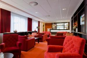 霍夫多普快捷假日酒店的一间设有红色椅子的等候室和一间酒吧