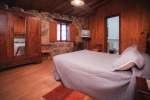 洛维奥斯卡萨巴拉罗旅馆的一间卧室设有一张床和石墙