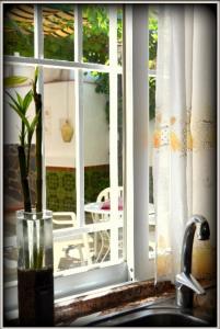 拉苏维亚玫瑰之角度假屋的坐在窗台旁水槽上的花瓶