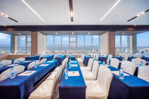 杭州杭州西湖东智选假日酒店的配有蓝色桌椅和窗户的客房