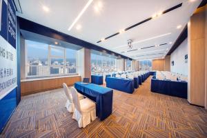 杭州杭州西湖东智选假日酒店的一间会议室,配有蓝色的椅子和大窗户