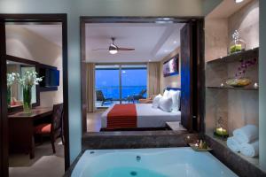 巴亚尔塔港Sunset Plaza Beach Resort Puerto Vallarta All Inclusive的酒店客房设有浴缸和卧室。