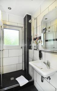 伍珀塔尔奴勒霍夫酒店的一间带水槽和镜子的浴室