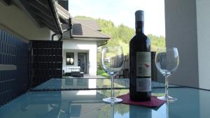克罗奇琴科DOMINO-APARTAMENTY Red的一张桌子上摆放着一瓶葡萄酒和两杯酒杯