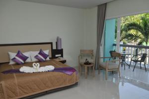 苏林海滩AM Surin Place - SHA Extra Plus的一间卧室设有一张床和一个阳台
