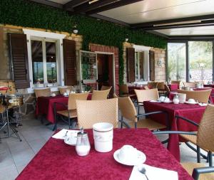 加尔达湖滨阿尔伯格贾尼奥奇达酒店的餐厅配有桌椅和红色桌布
