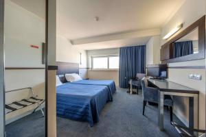 法蒂玛Hotel Santo Amaro - SA Hotels的配有一张床和一张书桌的酒店客房