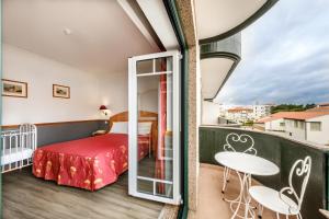 法蒂玛Hotel Santo Amaro - SA Hotels的一间卧室配有一张床,阳台配有桌子