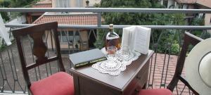 斯特雷萨拉罗卡达酒店的阳台上的桌子上摆放着一瓶葡萄酒和玻璃杯