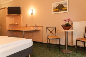 勒伯尔米利茨海滨酒店的酒店客房带一张床、一张桌子和椅子