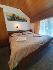 梅德沃代Pri Ancki B&B Ljubljana suburbs的一间卧室配有一张大床和两条毛巾