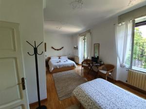贝加莫伊格里住宿加早餐旅馆的一间卧室设有两张床、一张桌子和一个窗口。