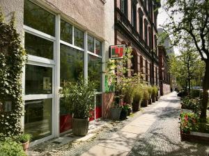 柏林Lekkerurlaub的一条空荡荡的街道,在一座种植盆栽植物的建筑前